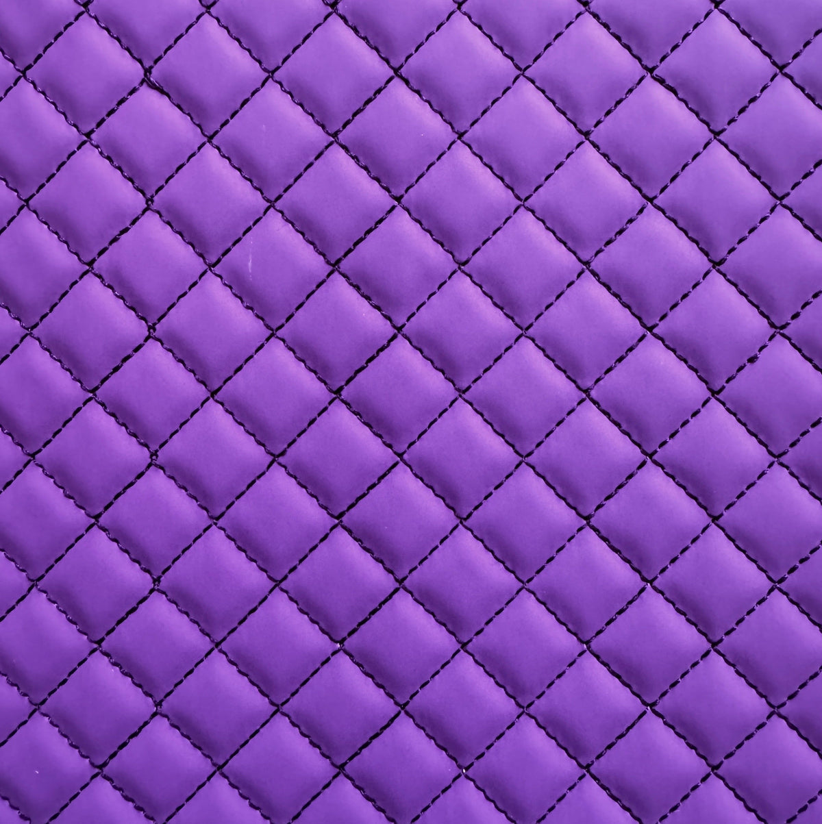 Close-up of purple quilted fabric with diamond pattern
